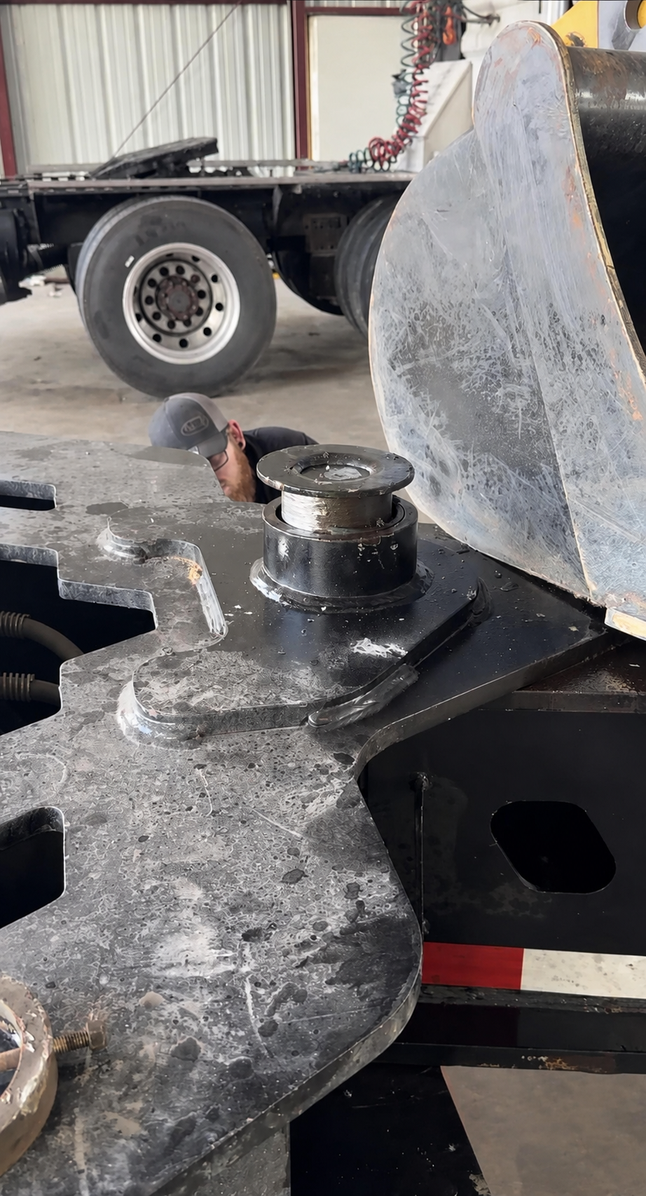 Close-up of heavy-haul trailer stinger bushing and pin removal in progress